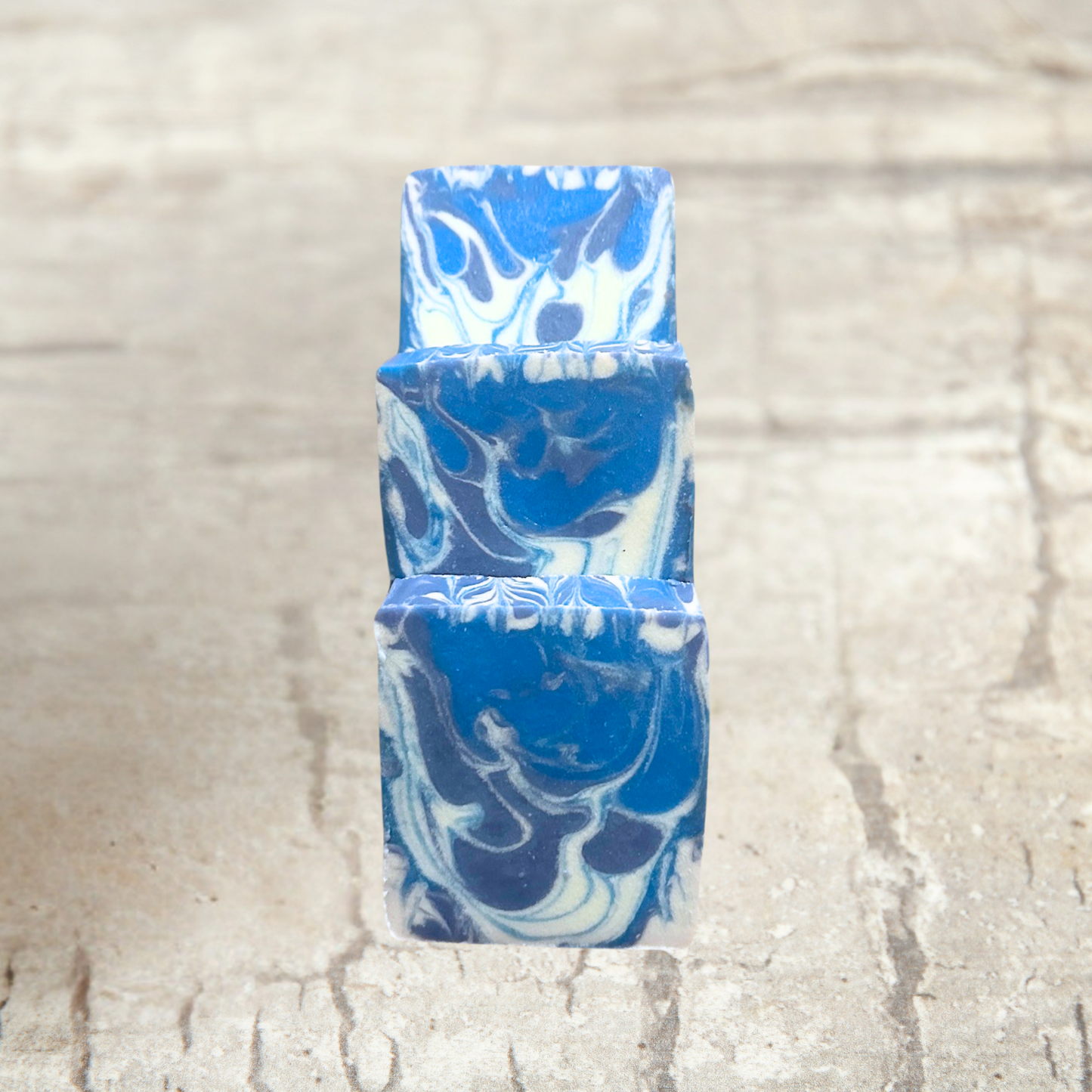 Blue and white marbled soap bars on a textured beige background