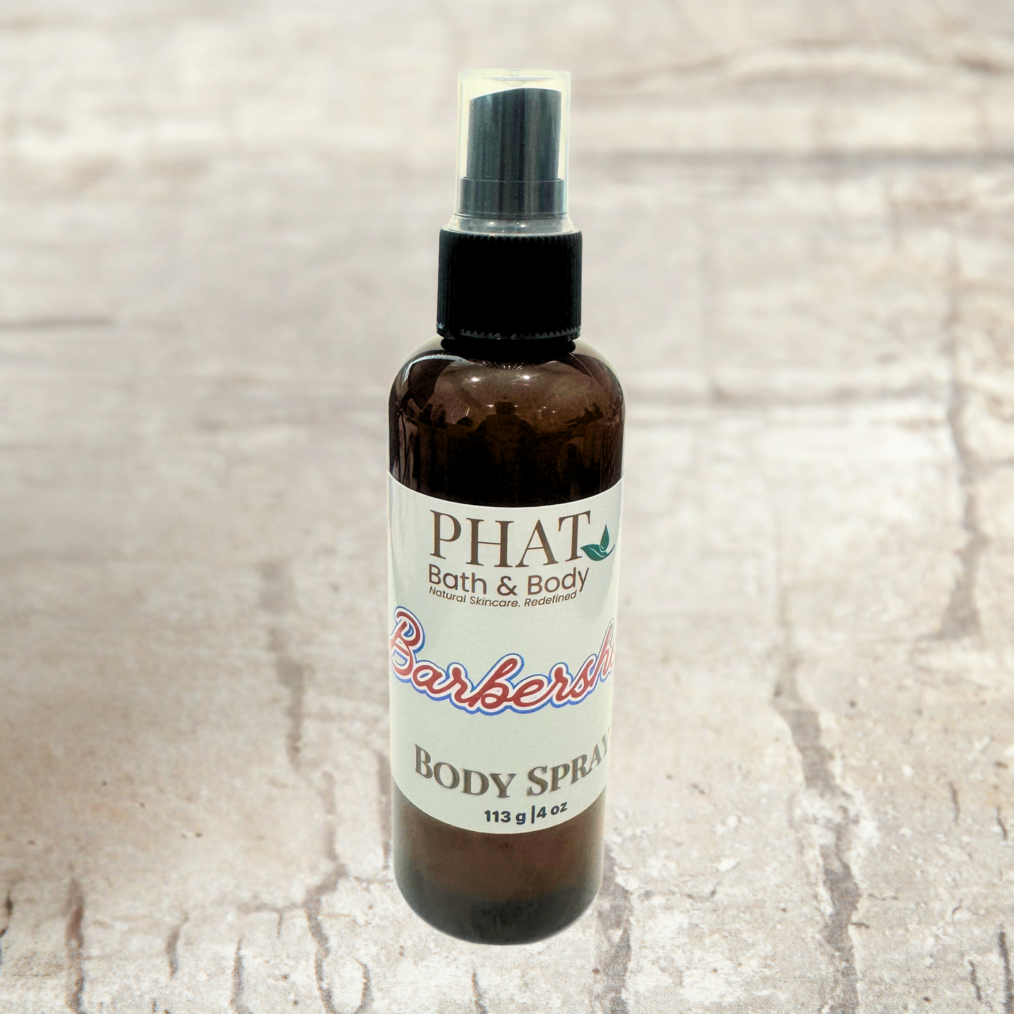 Body spray bottle with 'PHAT Bath & Body' label on a textured beige background