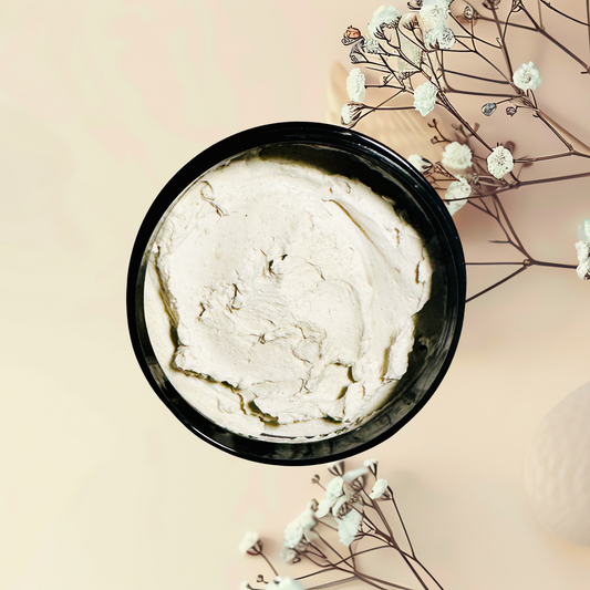 Black bowl with white mask on a light pink background with white flowers