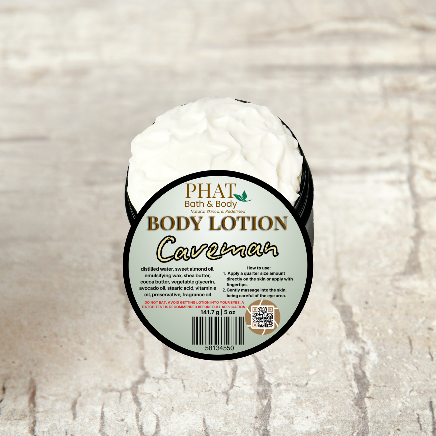 Body lotion container labeled 'Caveman' by Phat Bath & Body on a textured beige background