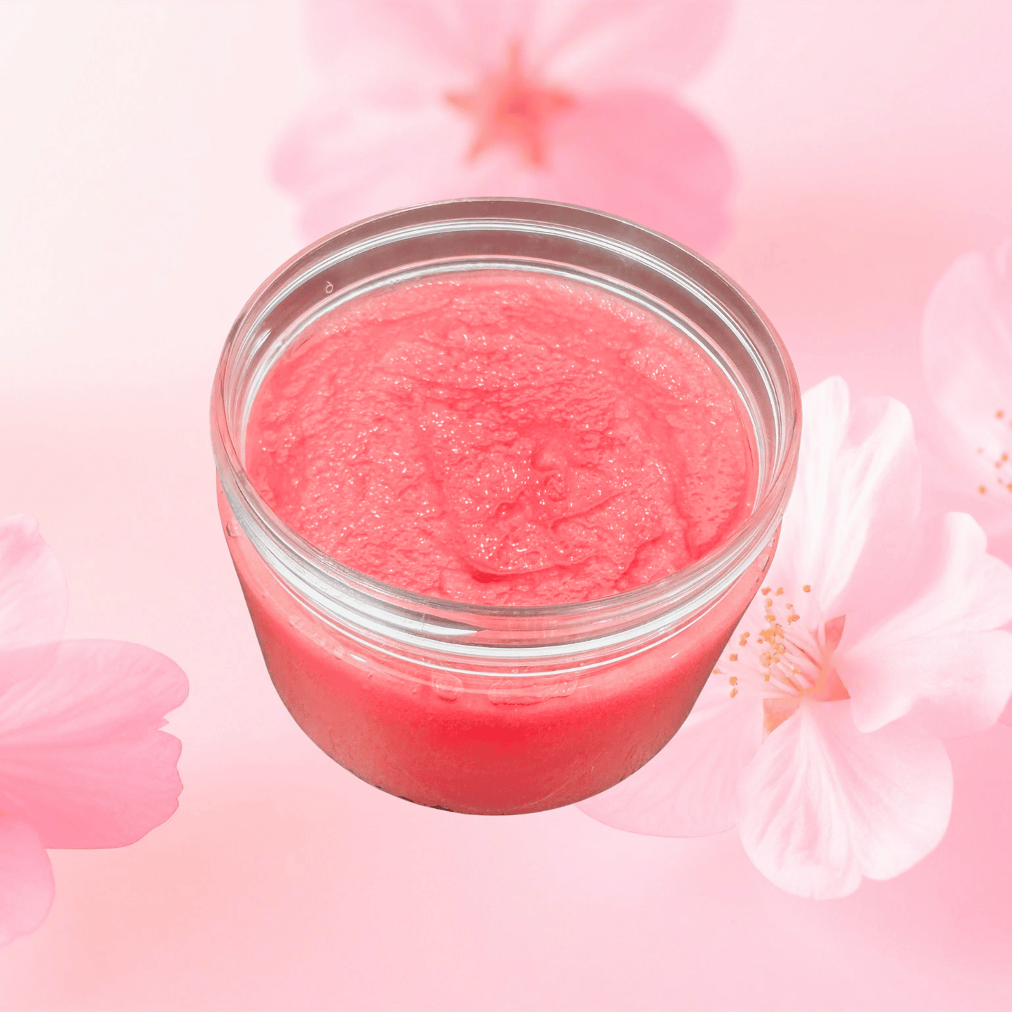 Jar of pink sugar scrub with cherry blossoms in the background