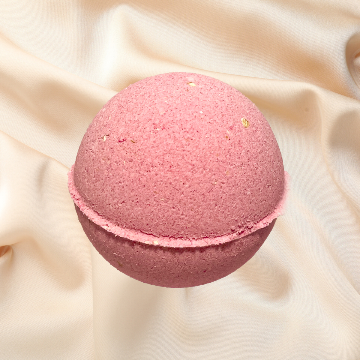 Pink bath bomb on a beige fabric background