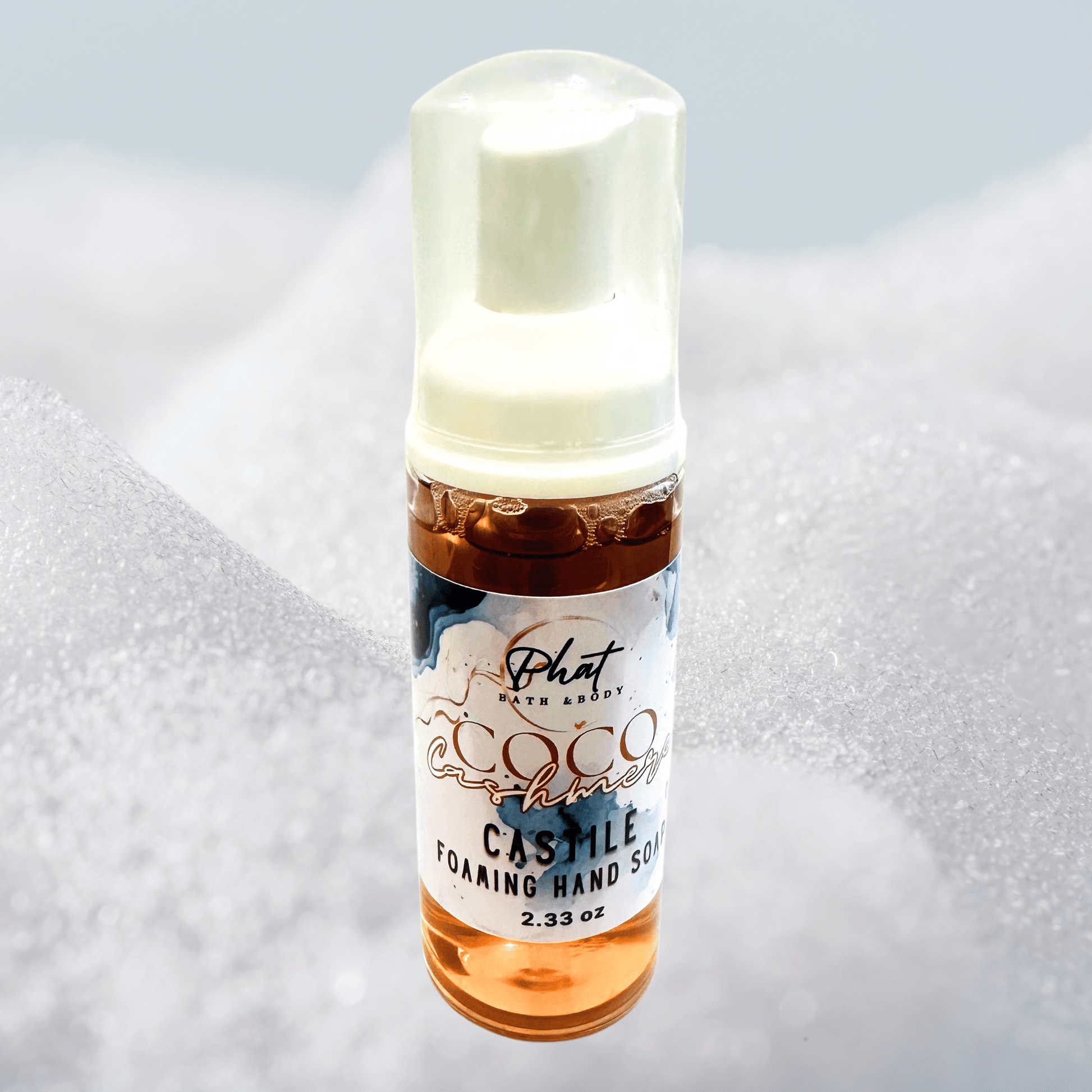 Bottle of Coco Cashmere foaming hand soap with a white cap on a textured gray background