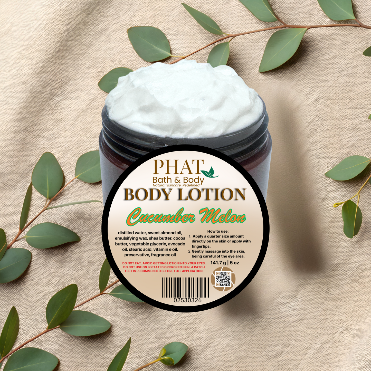 Body lotion jar labeled 'Cucumber Melon' from Phat Bath & Body on a beige fabric background with green leaves.