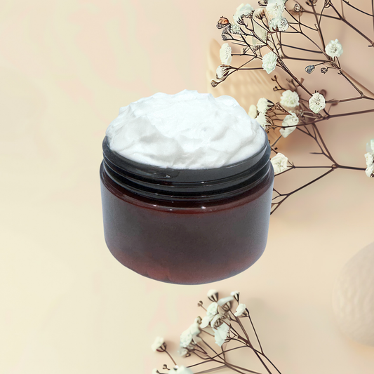 An open dark amber cosmetic jar filled with thick white cream, styled with dried white flowers on a soft beige background.