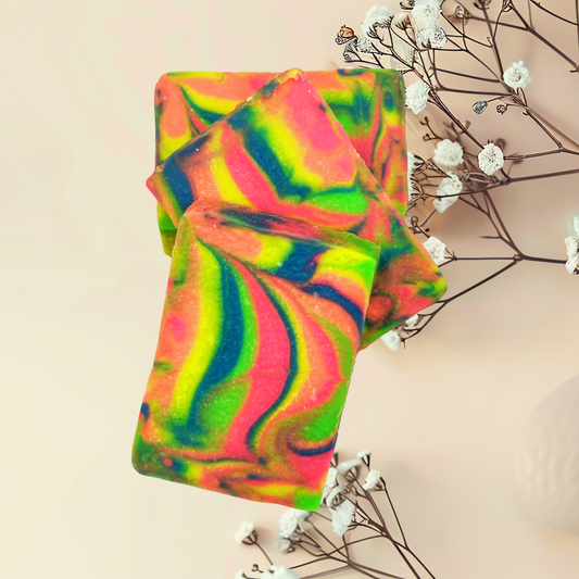Colorful tie-dye soap with a branch of white flowers on a beige background