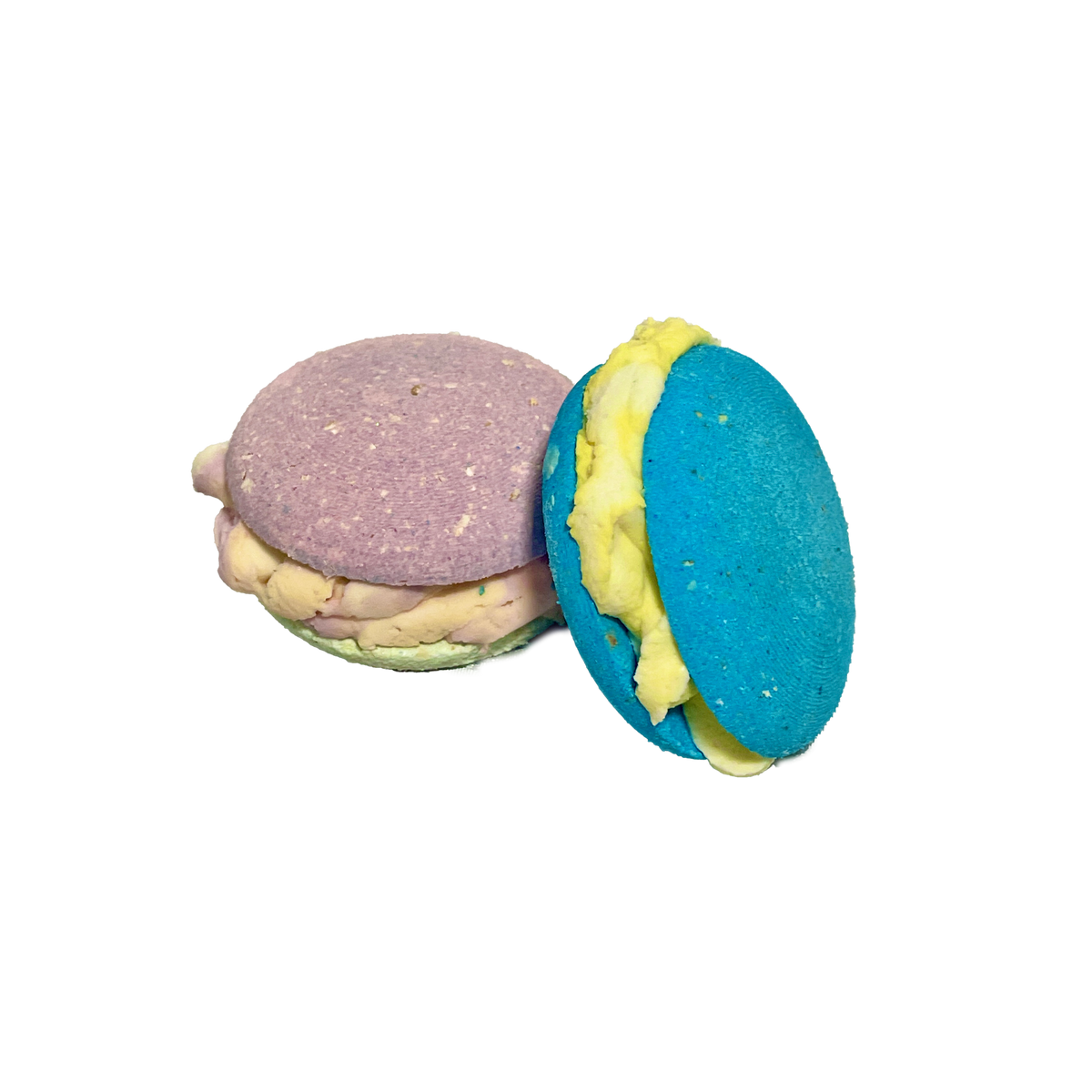 Two colorful macaron bubble bombs with different colored fillings on a white background