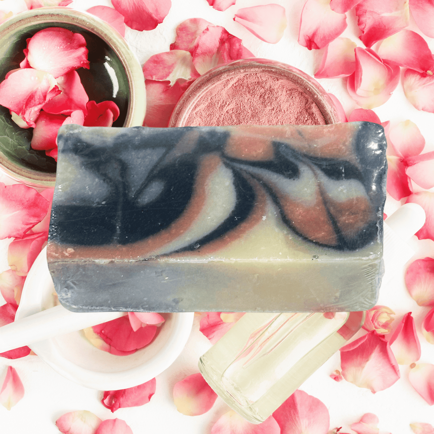Swirled clay soap bar on a background of pink rose petals