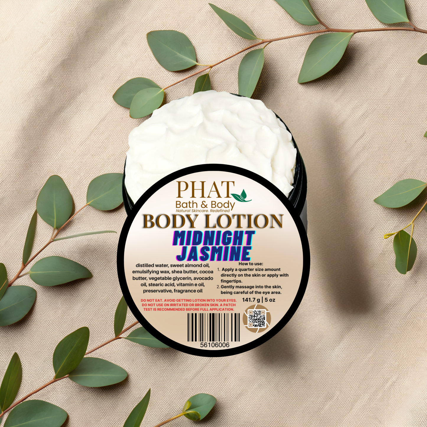 Body lotion container labeled 'PHAT Bath & Body Midnight Jasmine' on a beige fabric background with green leaves.