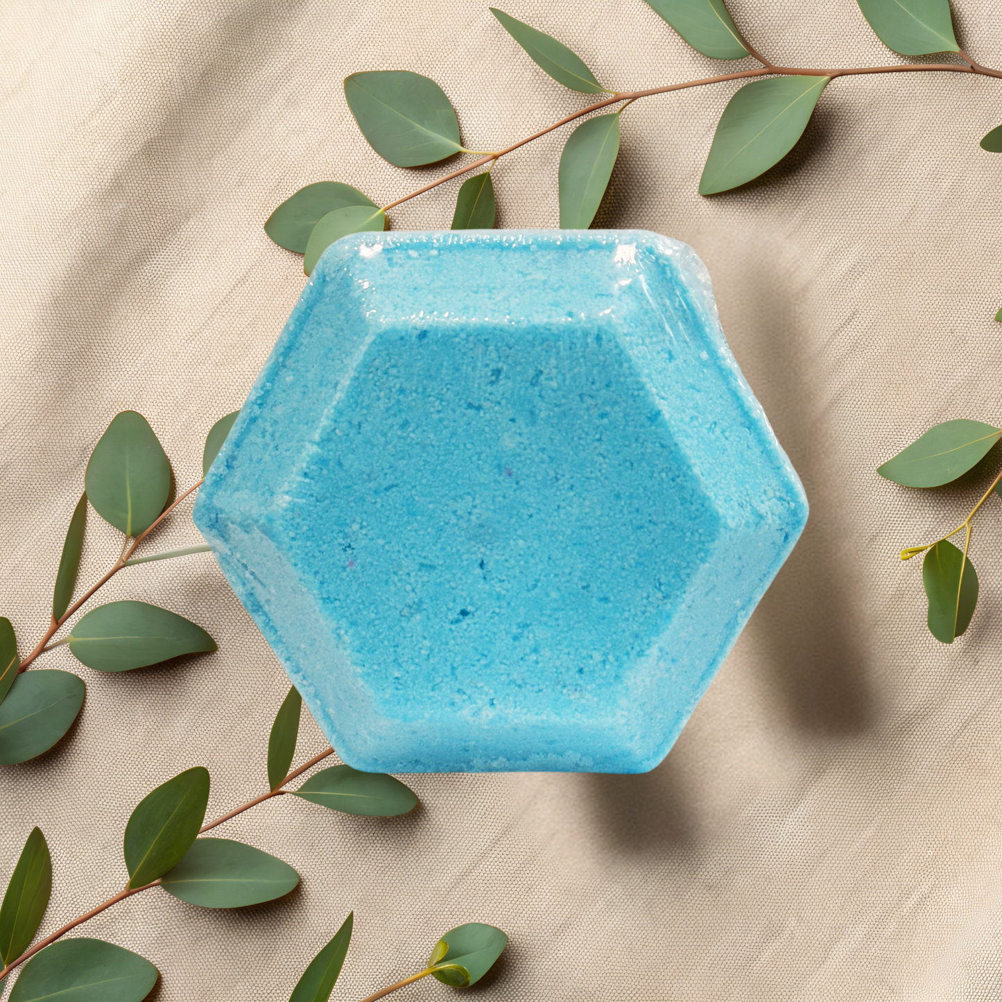 Hexagonal blue steamer on a beige fabric background with green leaves