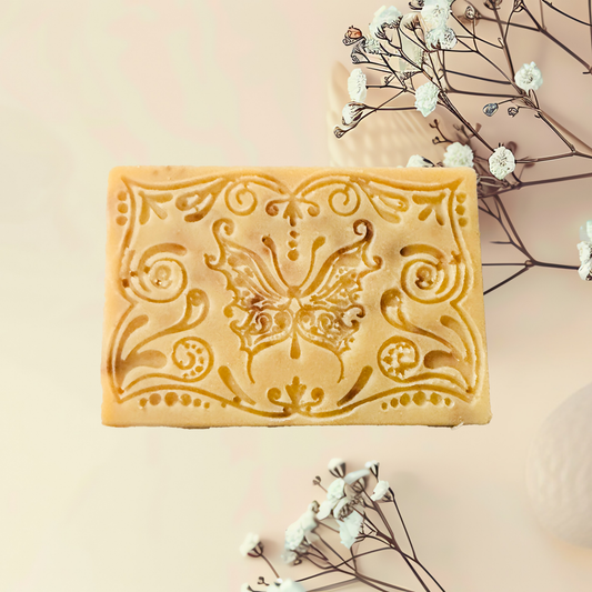 Decorative soap bar with intricate patterns on a light background with flowers.