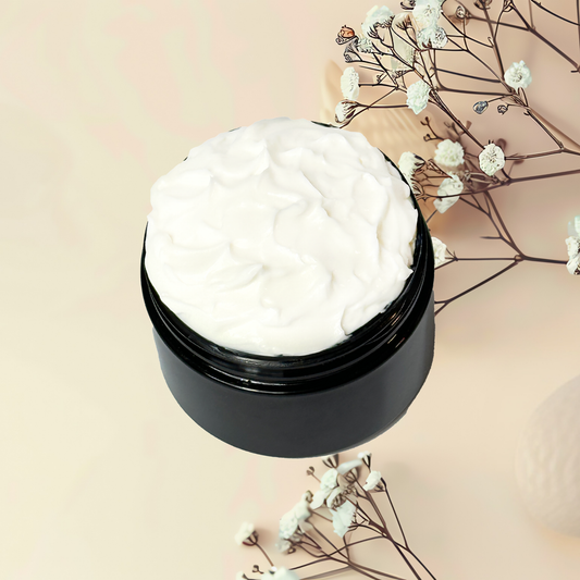 Black jar of white cream with dried flowers on a beige background