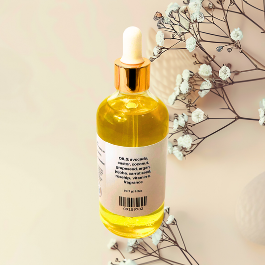 Bottle of yellow oil with dropper on a beige background with white flowers