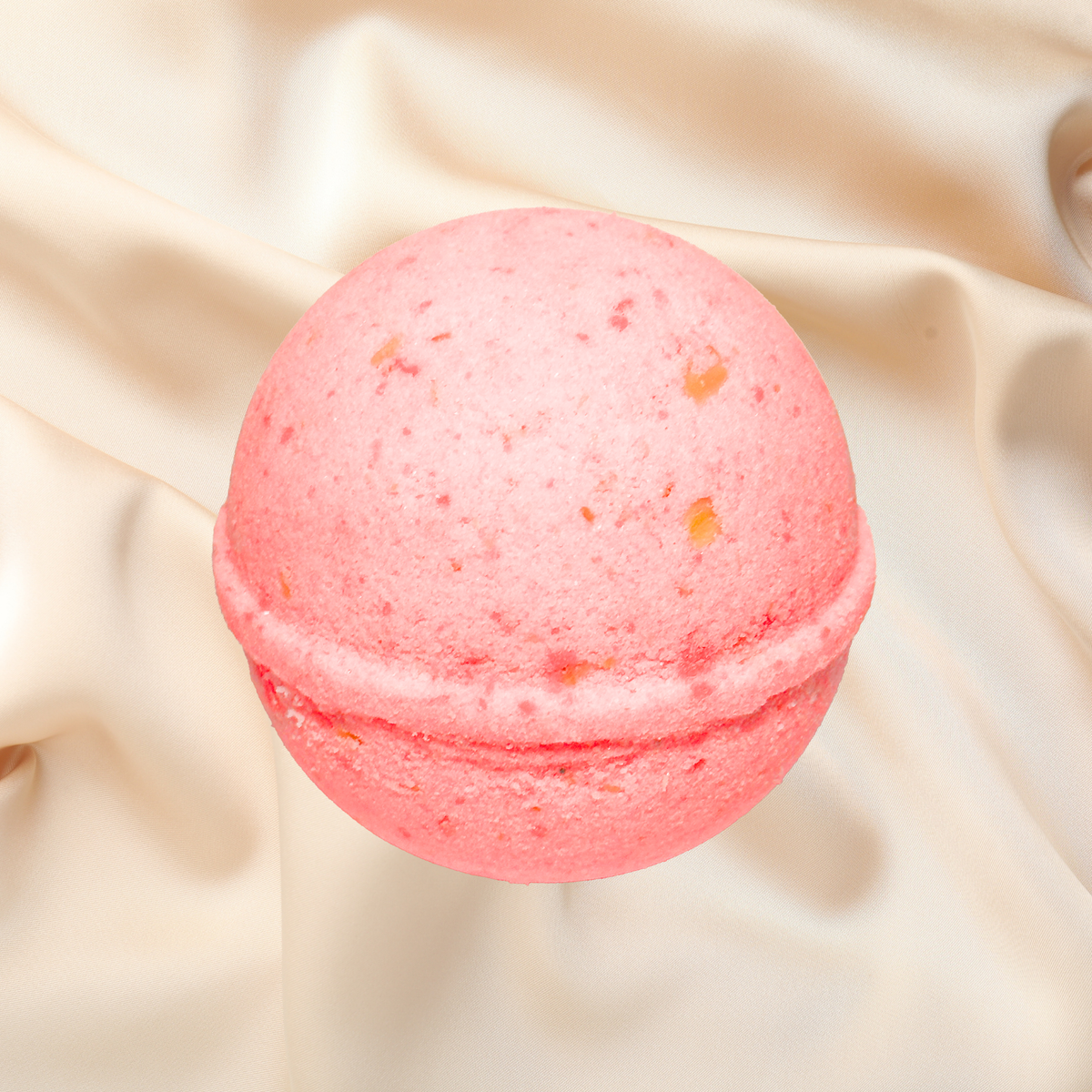 Pink bath bomb on a beige fabric background