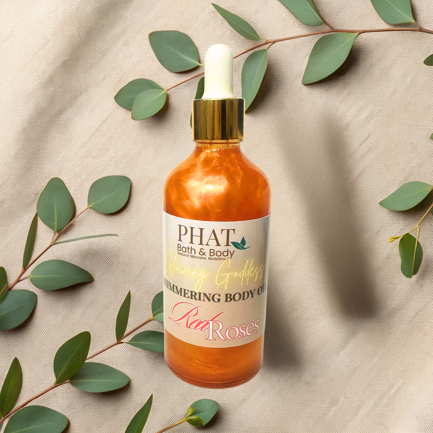 Bottle of 'PHAT Bath & Body' body oil with a dropper on a beige fabric background with green leaves.