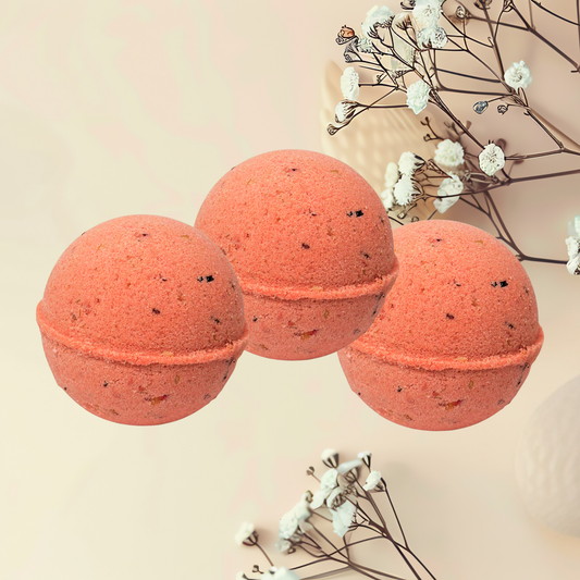 Three red bath bombs with natural elements on a beige background