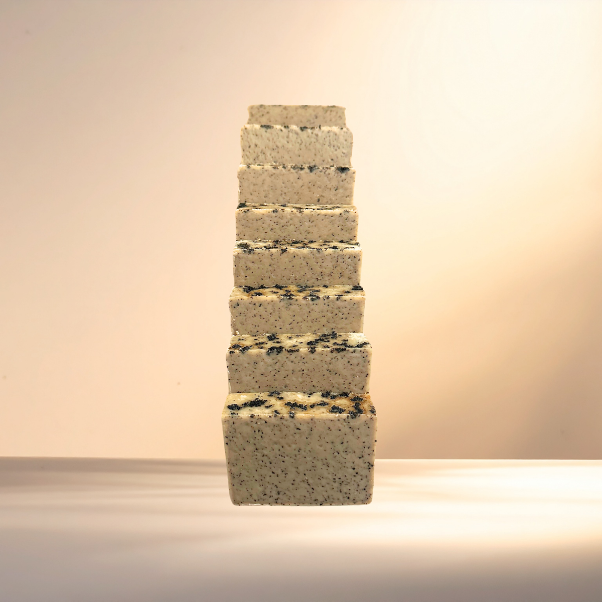 Stack of square soaps with a textured surface on a neutral background