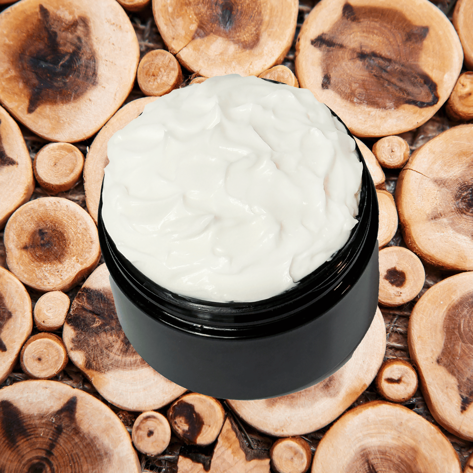 Black jar of sandalwood body lotion on a wooden surface