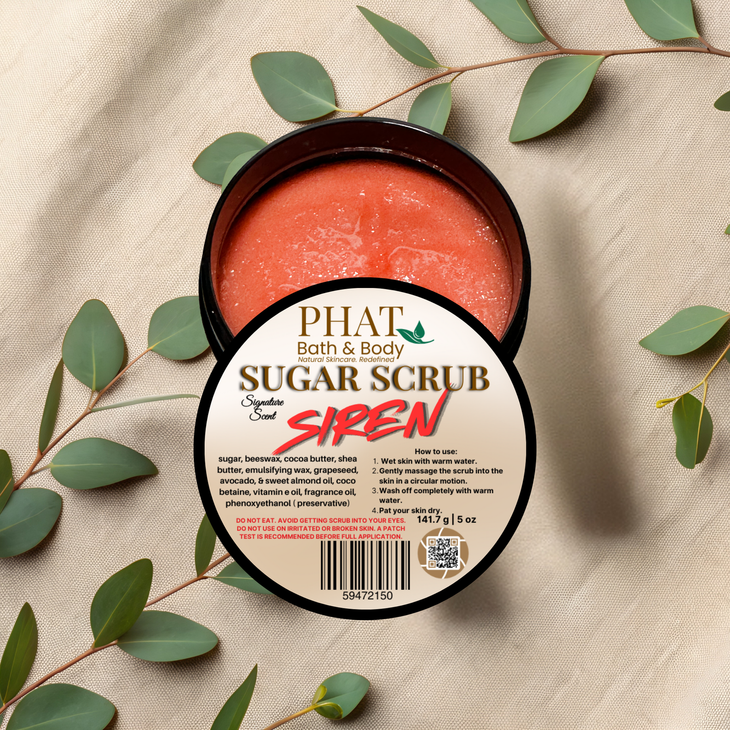 Jar of Phat Bath & Body Sugar Scrub Siren on a beige fabric background with green leaves.