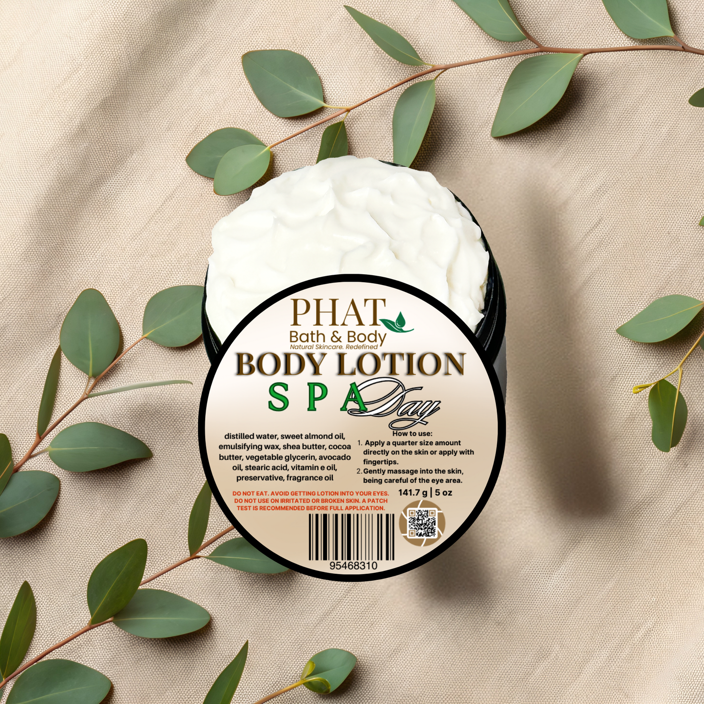 Body lotion container with 'Phat Bath & Body' label on a beige fabric background with green leaves.