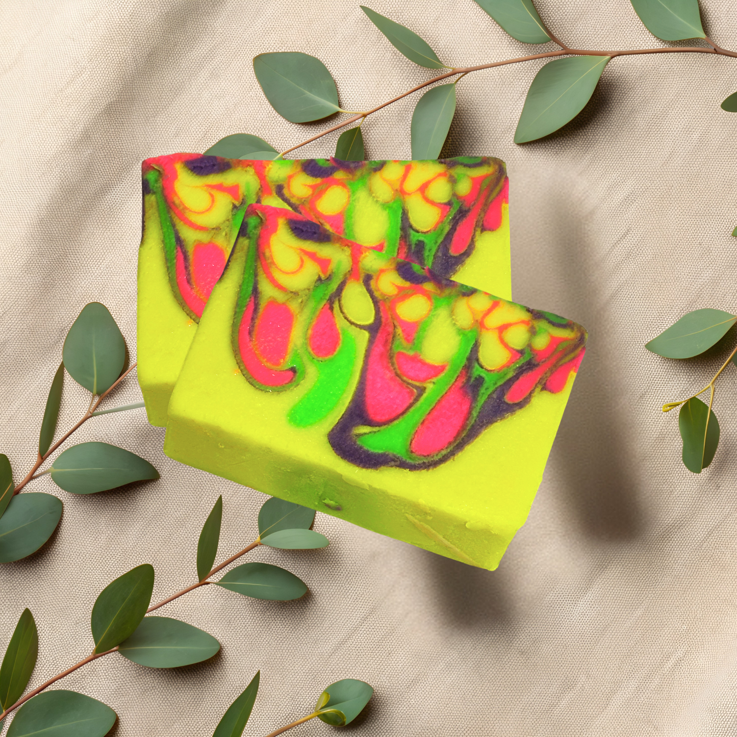 Colorful soap bar with green leaves on a beige fabric background