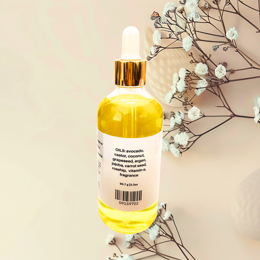 Bottle of yellow liquid with a dropper on a beige background with white flowers.