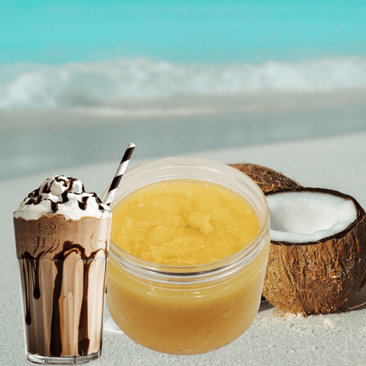 Jar of sugar scrub, chocolate milkshake, and coconut on a beach.