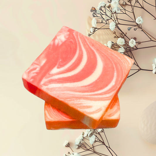 Pink and orange swirled soap bar with white flowers on a beige background