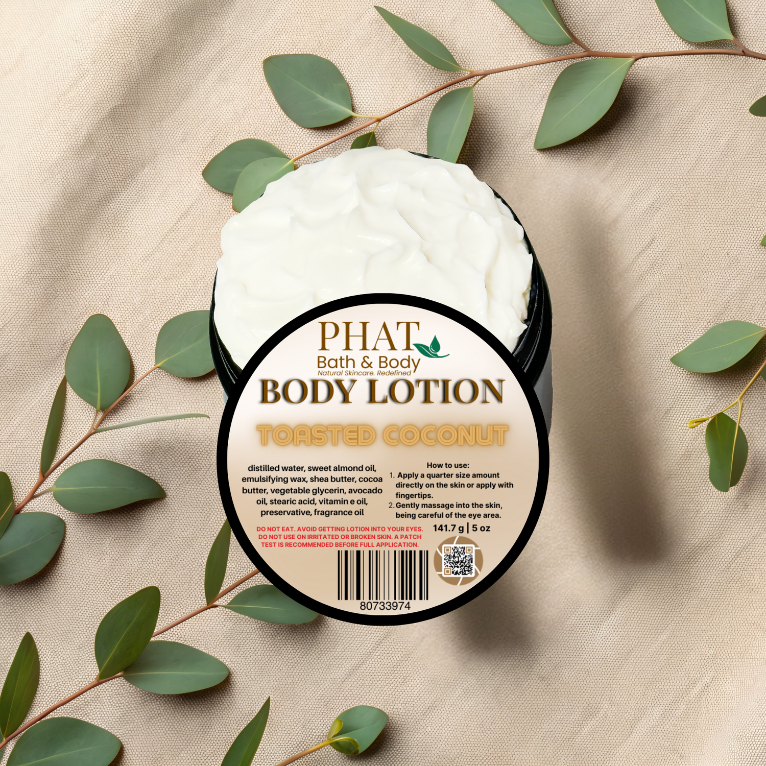 Body lotion container labeled 'PHAT Bath & Body' with eucalyptus leaves on a beige fabric background