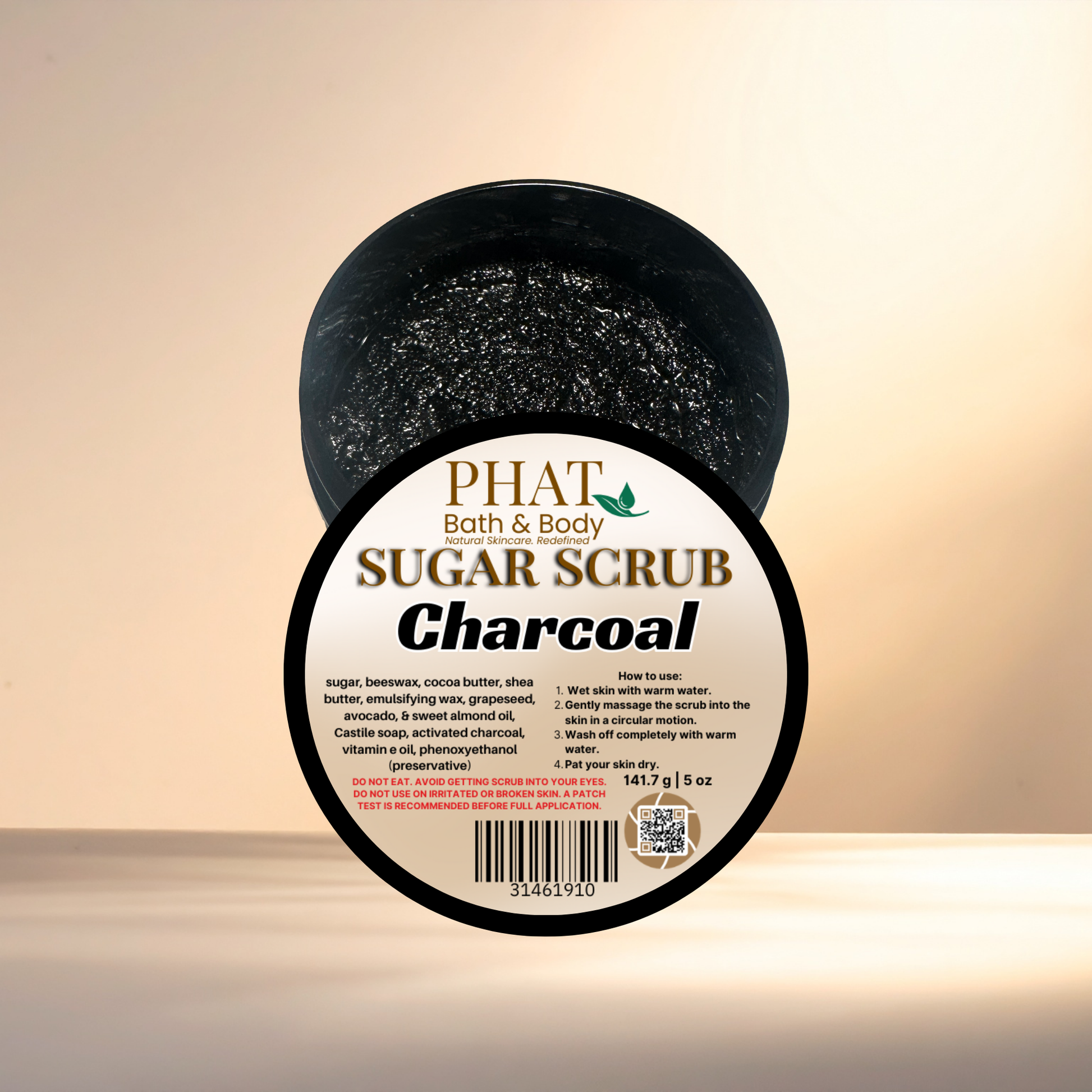 Jar of charcoal sugar scrub with 'Phat Bath & Body' label on a beige background