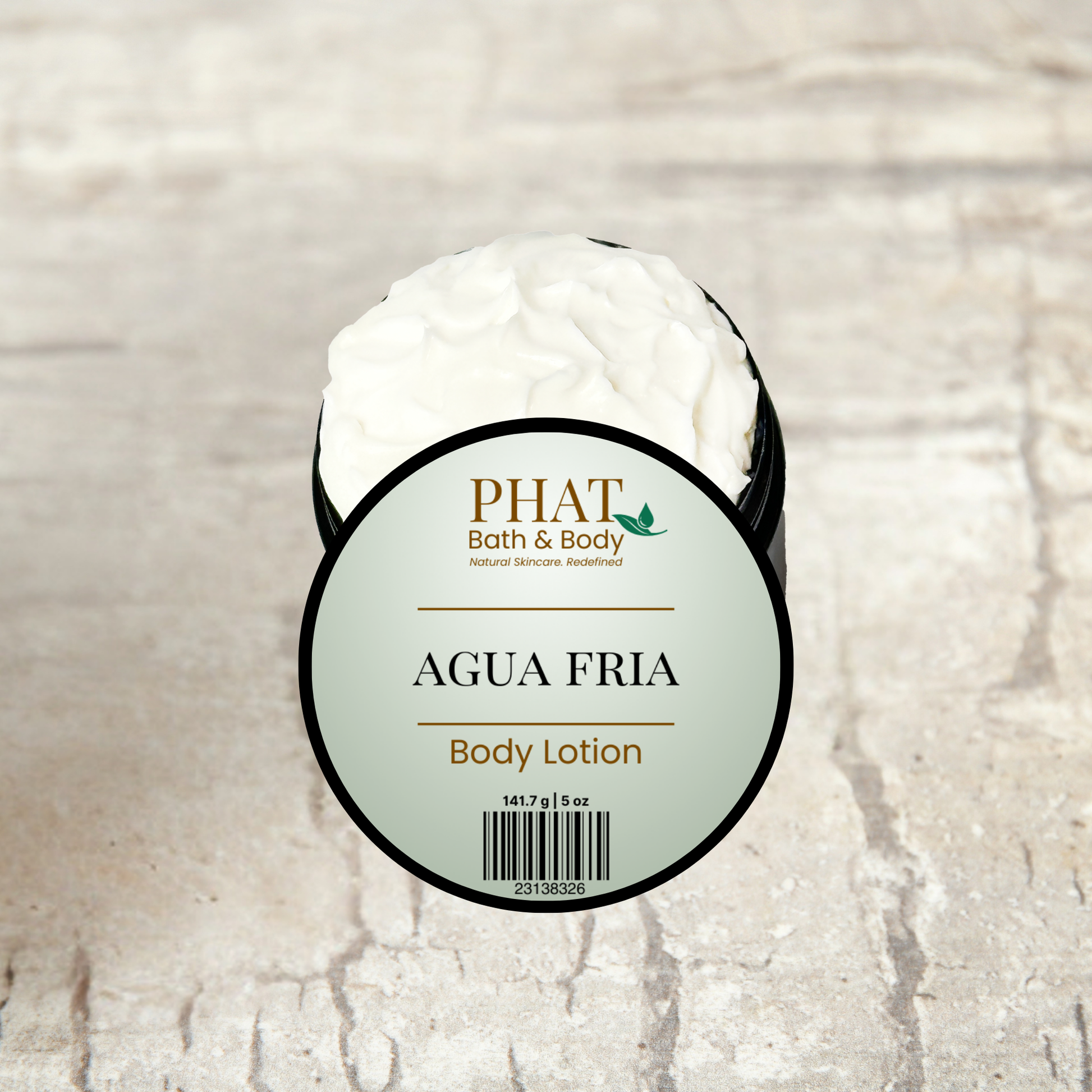 Body lotion container labeled 'AGUA FRIA' by PHAT Bath & Body on a textured beige background
