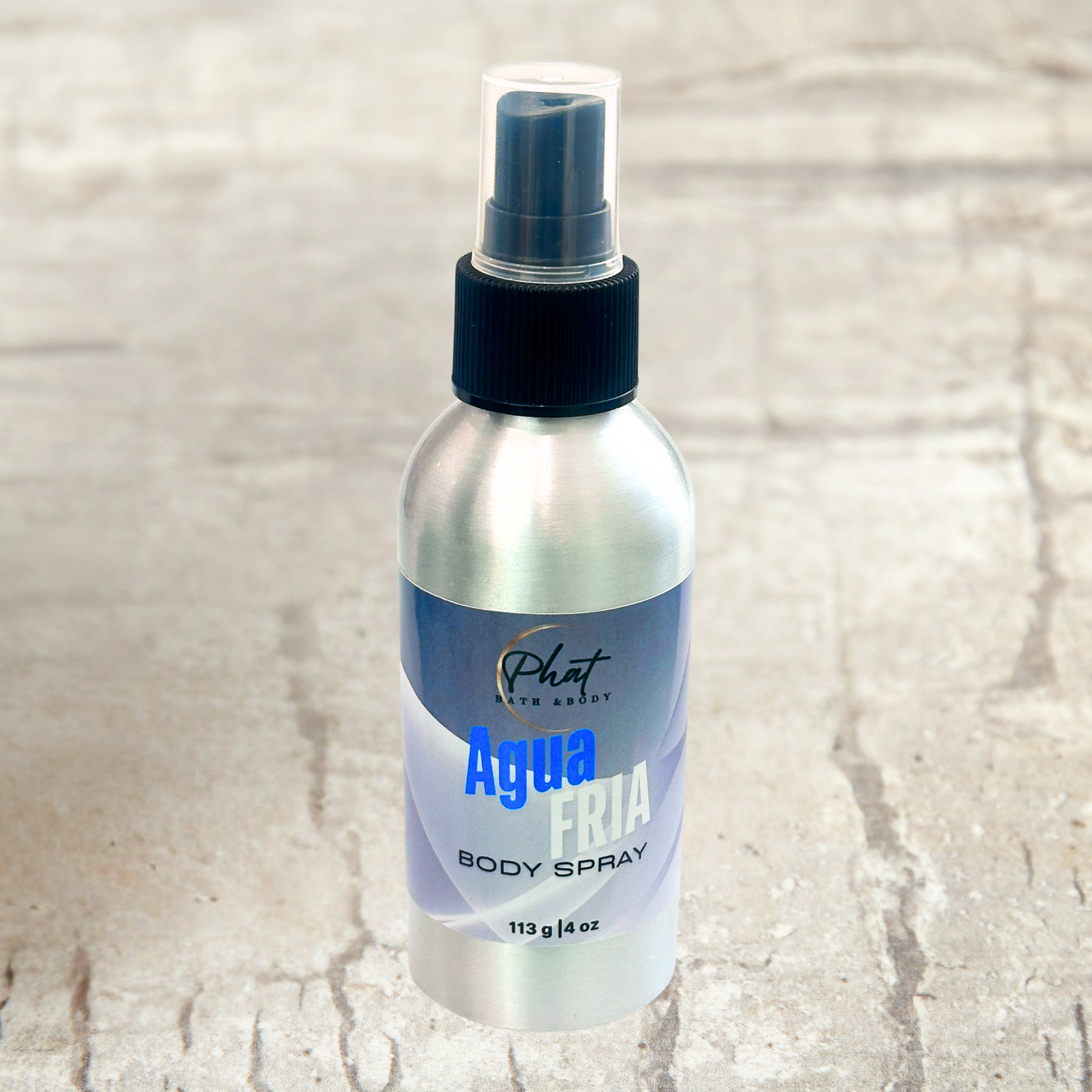 Body spray bottle labeled 'Agua Fria' on a textured beige background