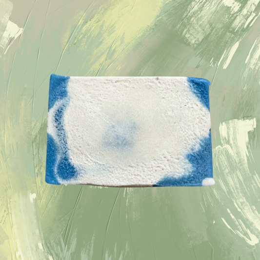 Rectangular soap bar with blue and white swirls on a green textured background