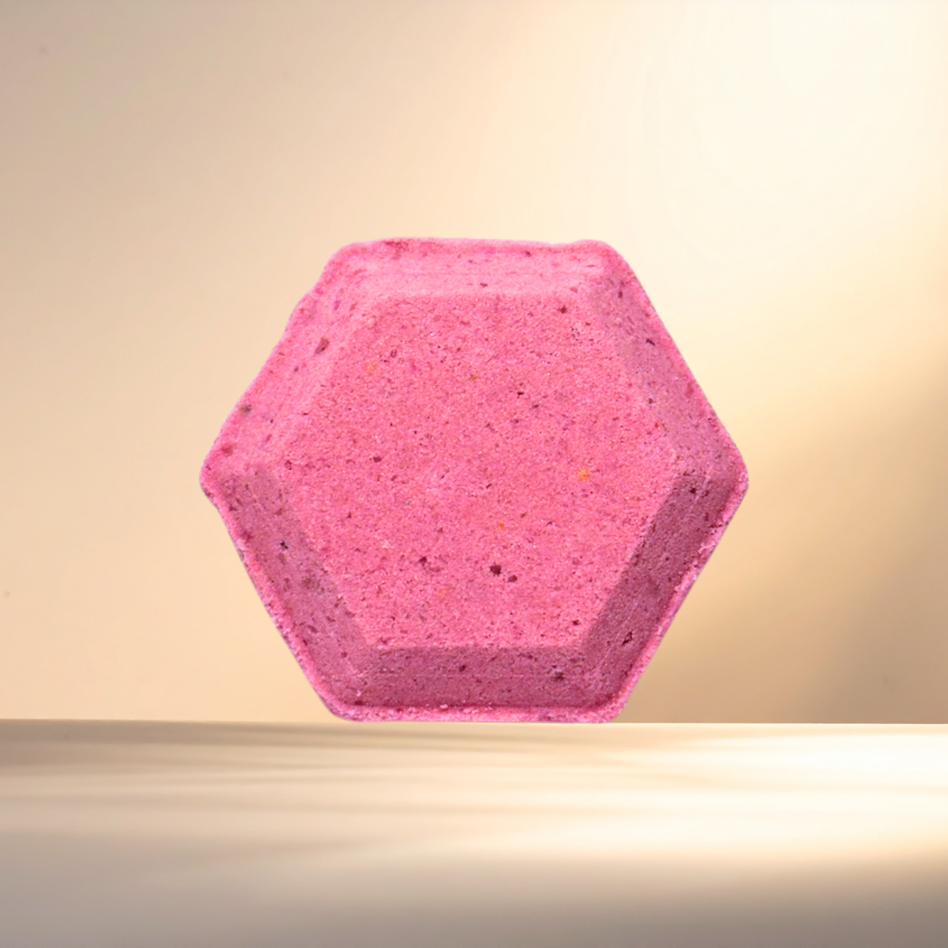 Hexagonal pink shower bomb on a beige background