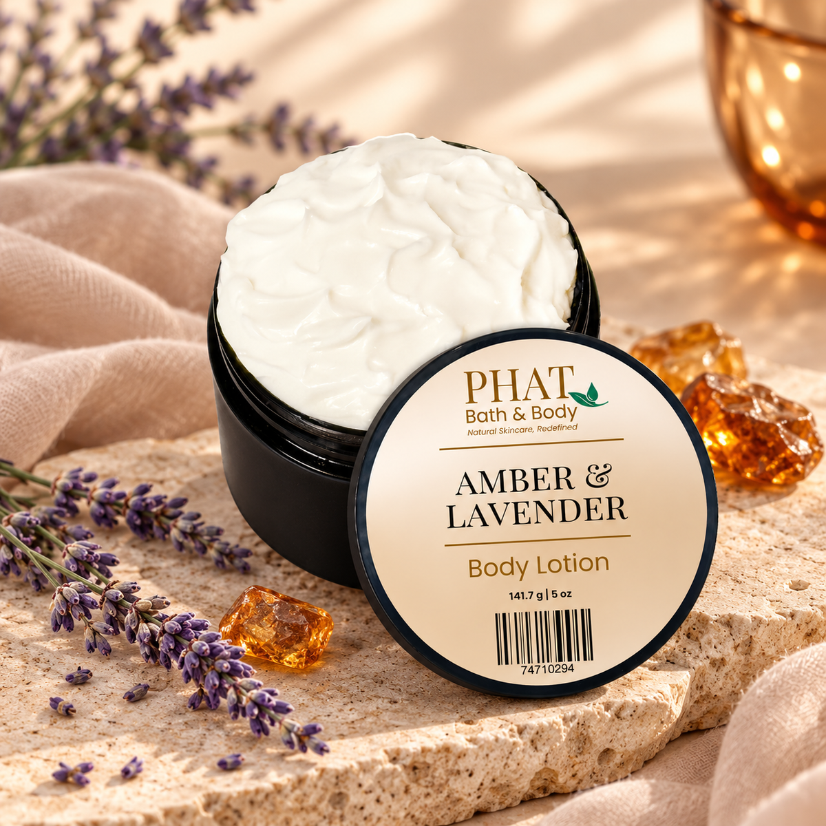 Amber & Lavender Body Lotion with labeled lid displayed among lavender, glowing amber accents, soft neutral fabric, and textured stone.