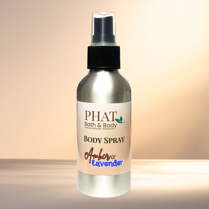 Body spray bottle labeled 'PHAT Bath & Body' with 'Amber & Lavender' scent on a gradient background