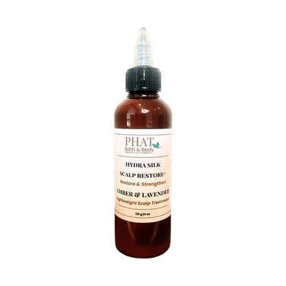 A amber bottle of PHAT Bath & Body Scalp Restore+ hair treatment with a black dropper cap and a cream-colored label, set against a plain white background.