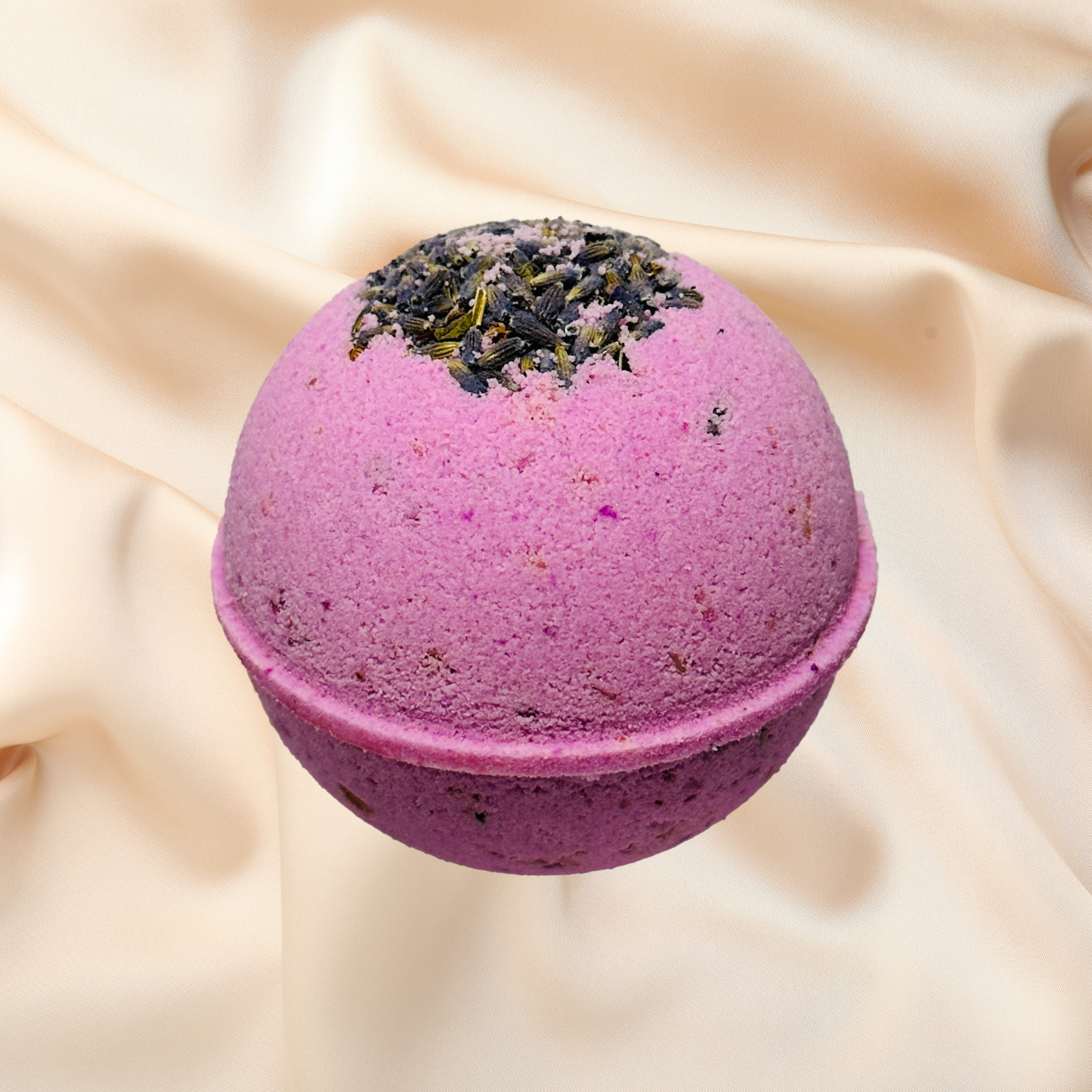 Purple bath bomb with greenery on top on a beige fabric background