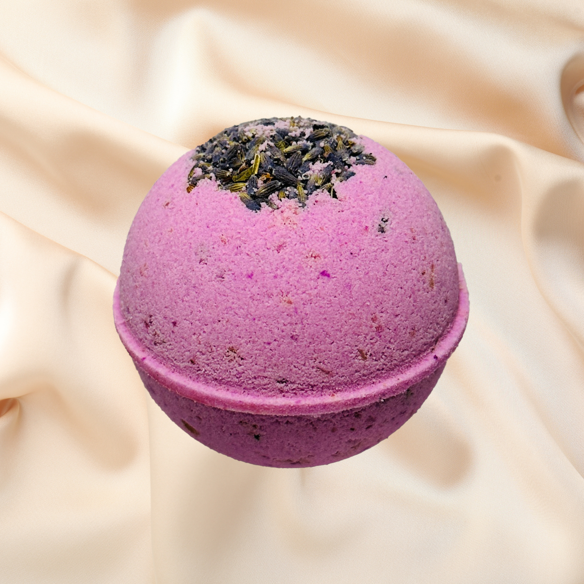 Purple bath bomb with greenery on top on a beige fabric background