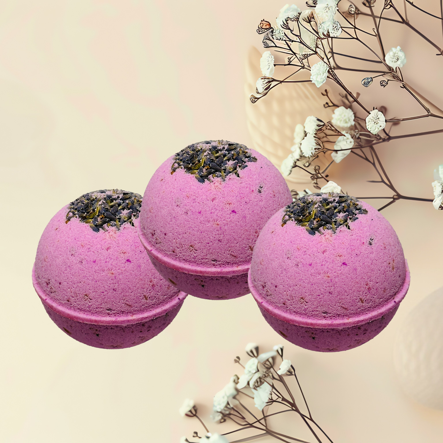 Three purple bath bombs with dry flowers on a light beige background