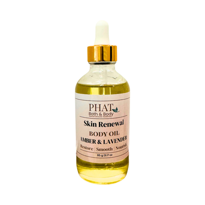 A bottle of PHAT Bath & Body Skin Renewal Body Oil in the Amber & Lavender scent, featuring a clear glass bottle filled with golden-yellow oil, a white label, and a gold cap with a white dropper, set against a plain white background.