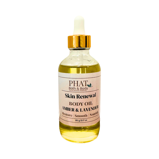 A bottle of PHAT Bath & Body Skin Renewal Body Oil in the Amber & Lavender scent, featuring a clear glass bottle filled with golden-yellow oil, a white label, and a gold cap with a white dropper, set against a plain white background.