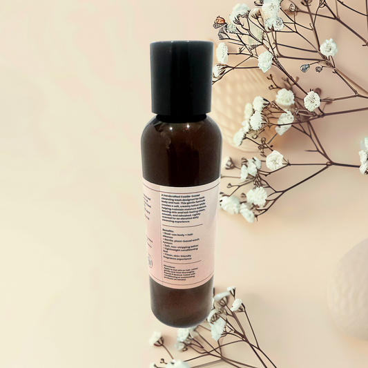 Brown bottle with black cap on a beige background with white flowers