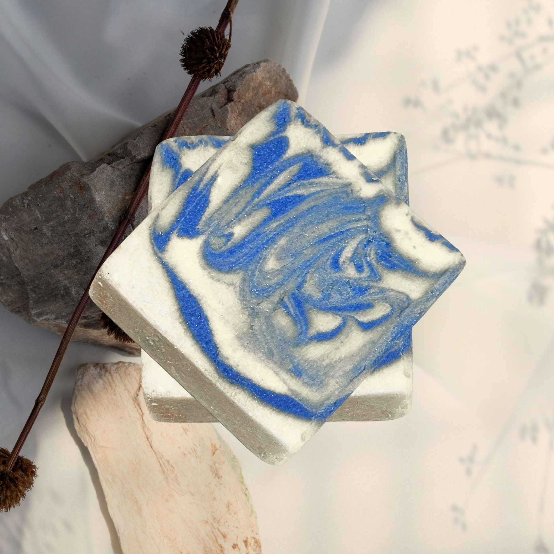 Bar of soap with blue and white swirl pattern on a natural stone background