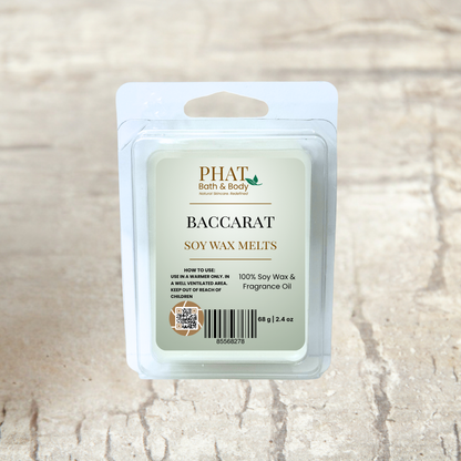 PHAT Bath & Body baccarat soy wax melts packaging on a beige fabric background with green leaves.