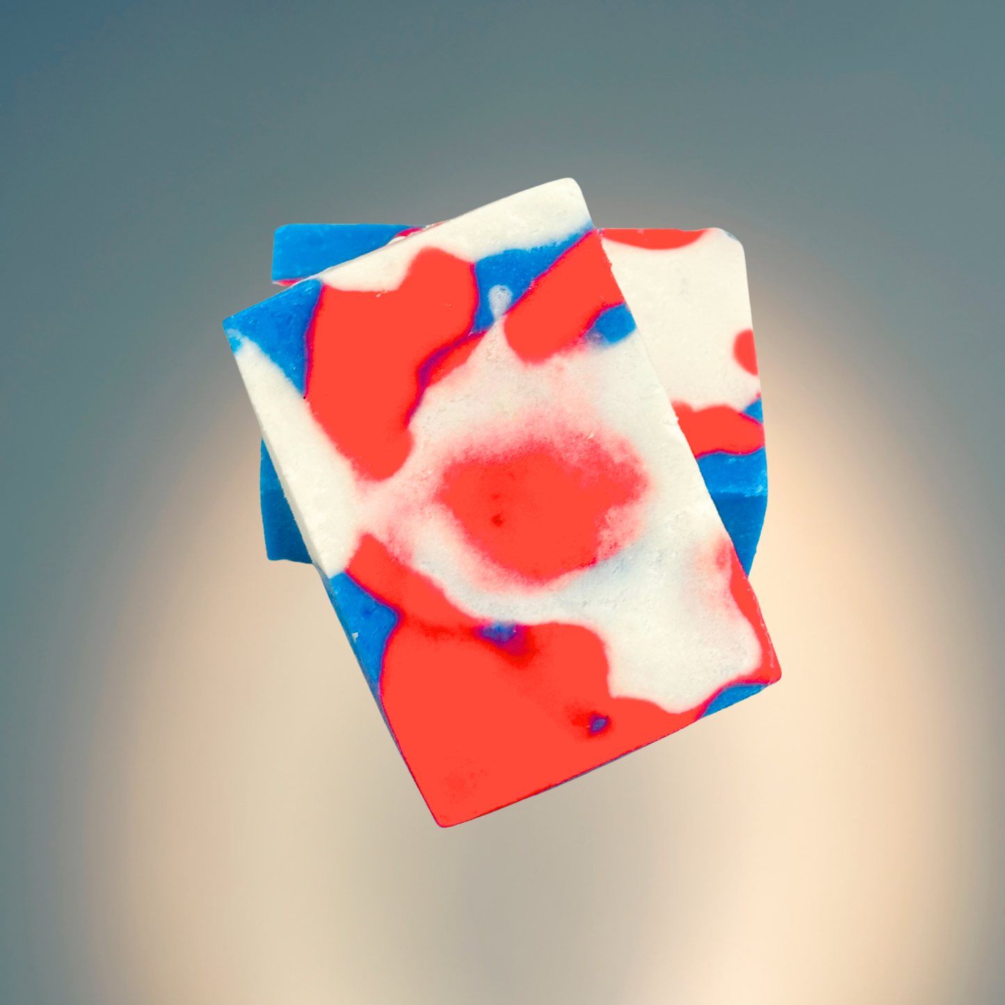 Colorful soap bar with red, white, and blue swirls on a gradient background