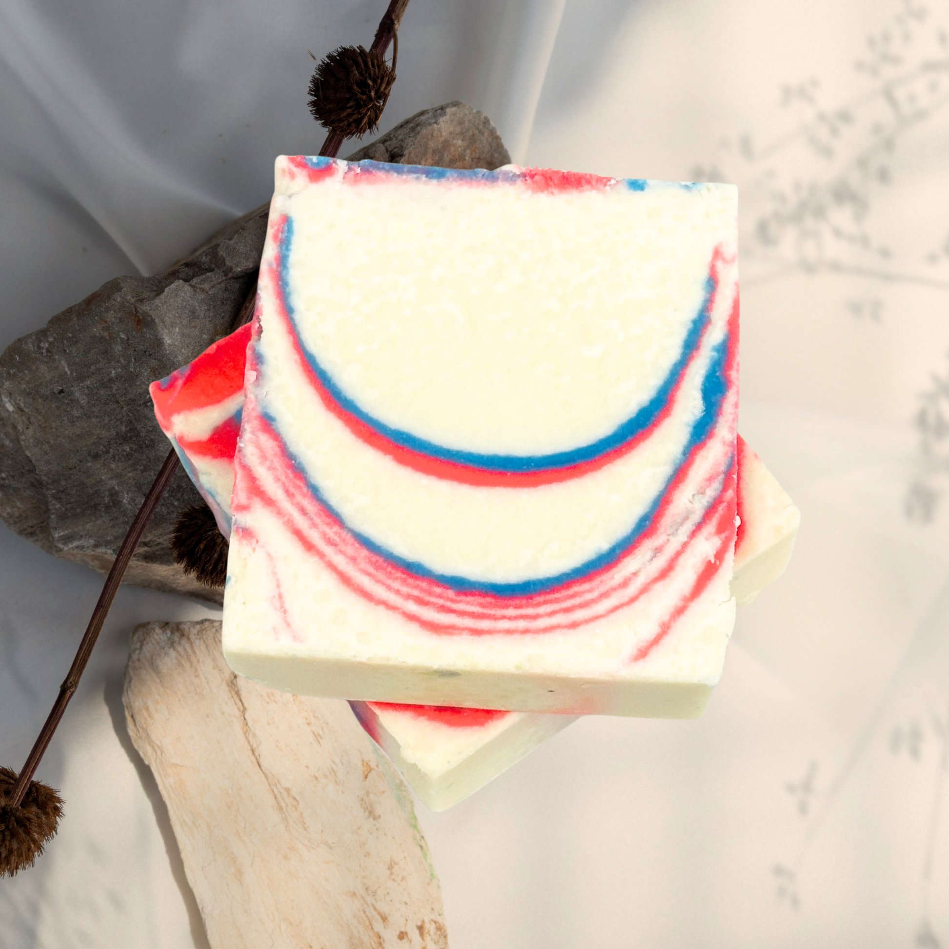 Bar of soap with red and blue swirls on a natural stone background
