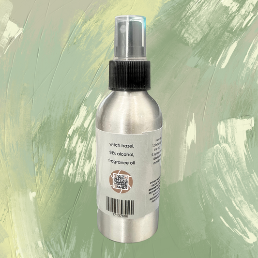 Silver spray bottle with a label on a green textured background