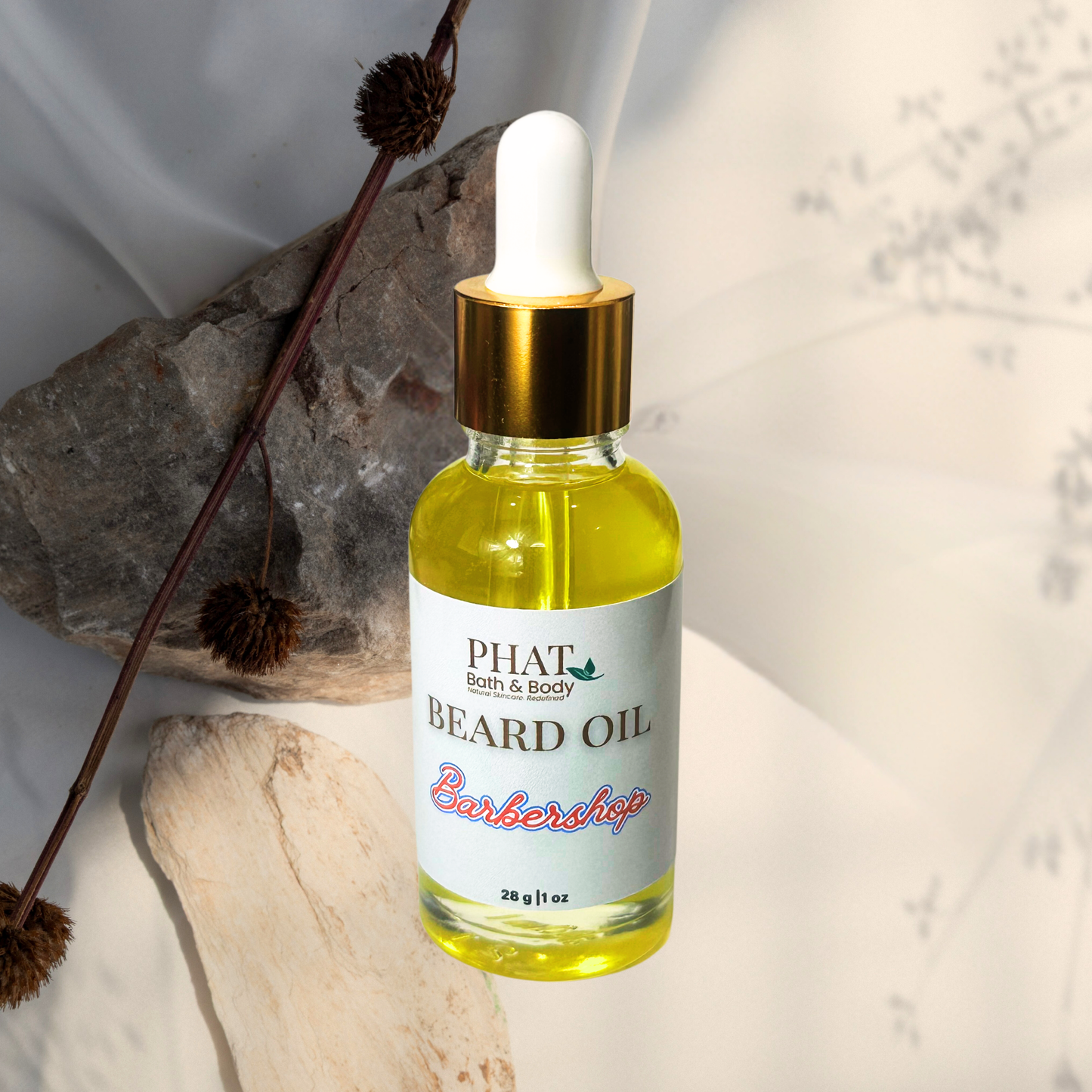 Bottle of Phat Bath & Body Beard Oil with a dropper on a textured surface.