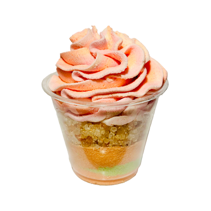 Bath parfait cup with pink and orange swirled topping on a white background